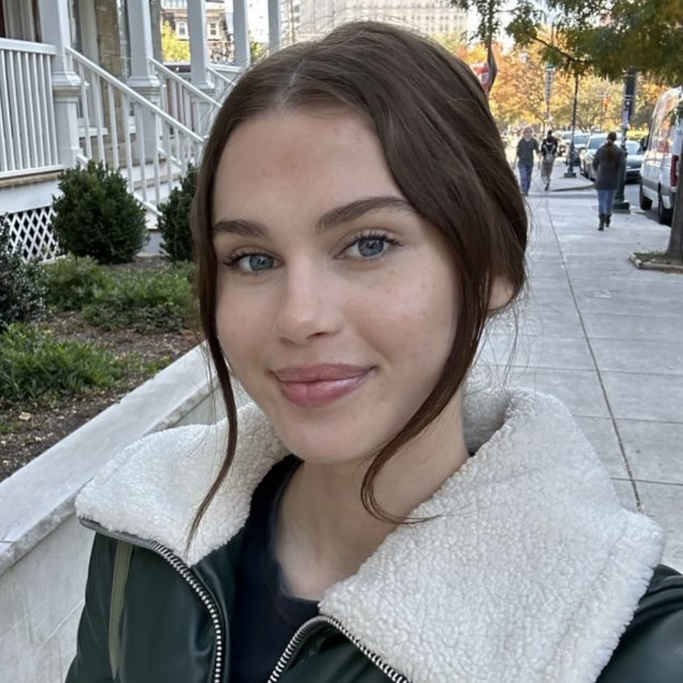 A portrait of Dagny Shepherd smiling and wearing a jacket with a large white collar